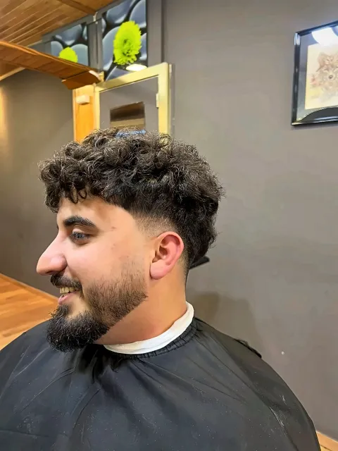Herenknip met krullen, fade en verzorgde baard